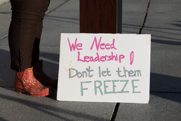 speaker's shoes next to sign reading "we need leadership! Don't let them freeze"