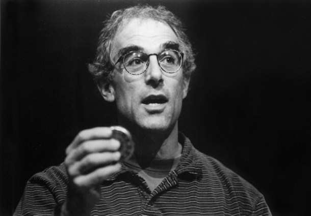 Larry Gordon with hand raised holding round object