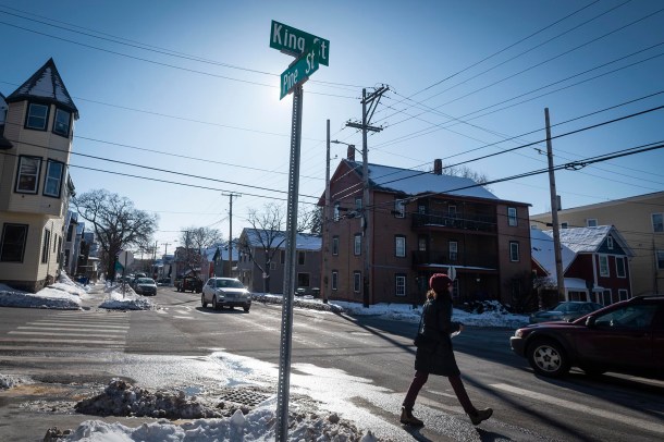 Street signs at intersection with person crossing
