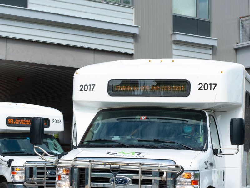 Two white buses parked next to each other.