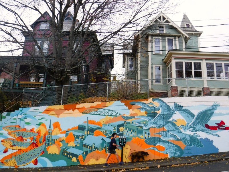 a person walks in front of a mural painted in blues and oranges