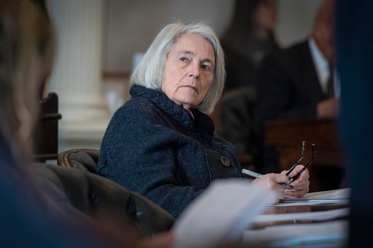 A woman sitting at a table with papers in front of her.
