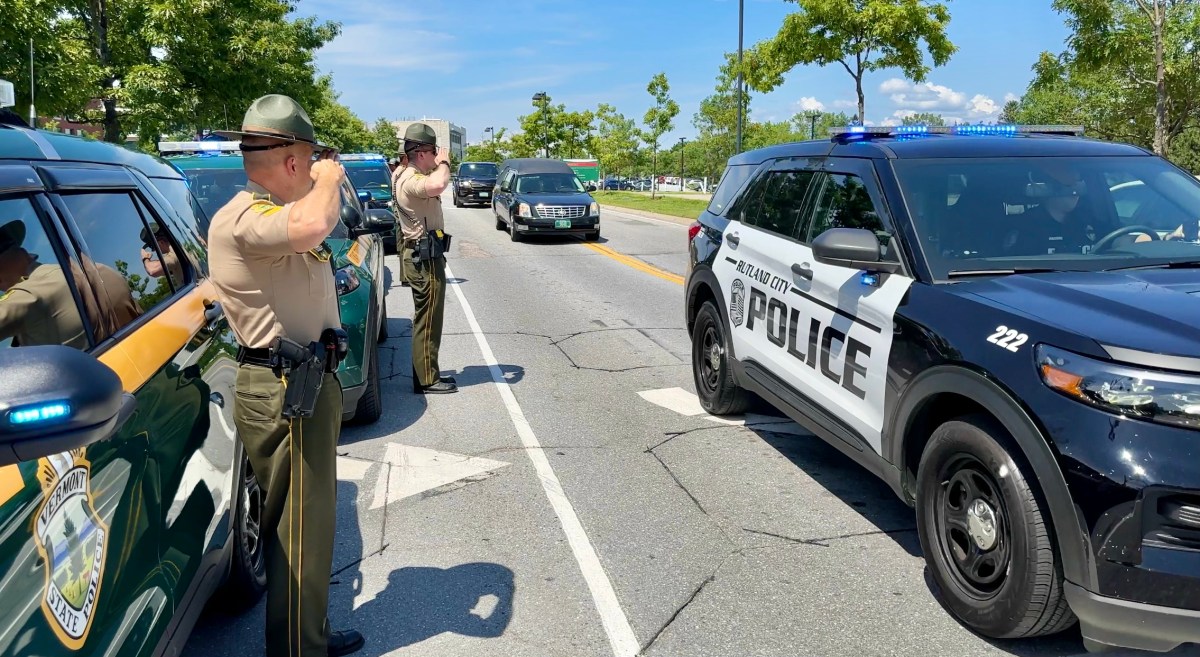 a group of police officers standing on the side of the road.