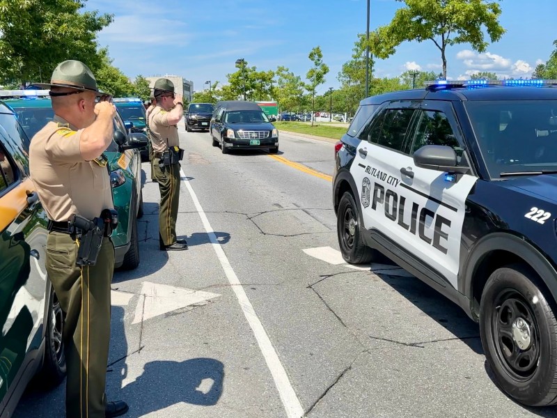 a group of police officers standing on the side of the road.