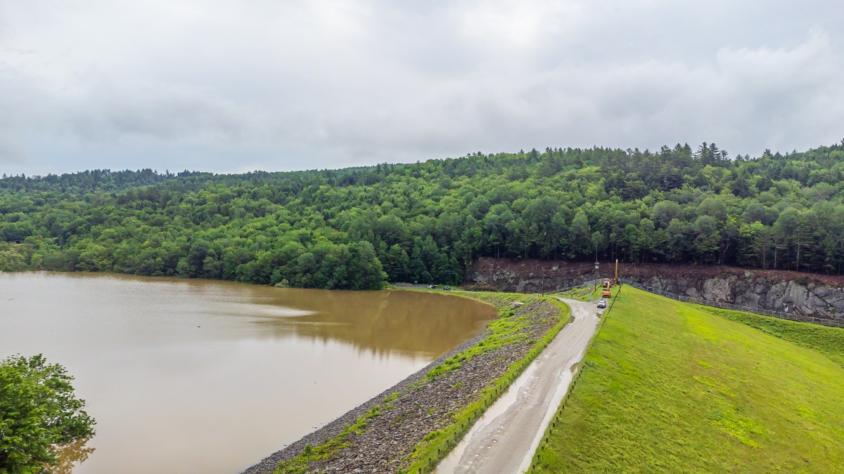 an aerial view of a river with a dam in the background.