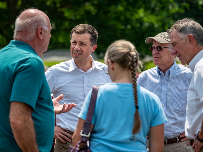 a group of people talking to each other in a park.