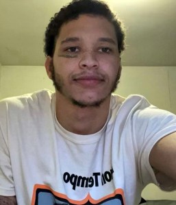 A young man with tattoos and a t - shirt.