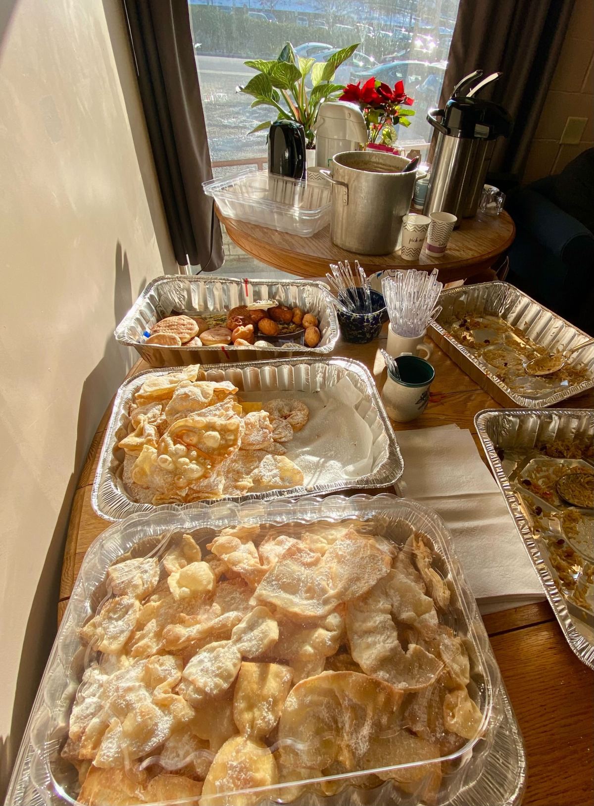 Trays of food on a table next to a window.