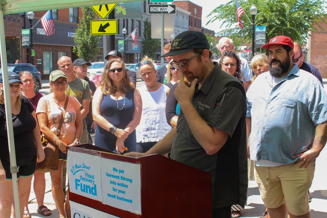 a man standing at a podium in front of a crowd.
