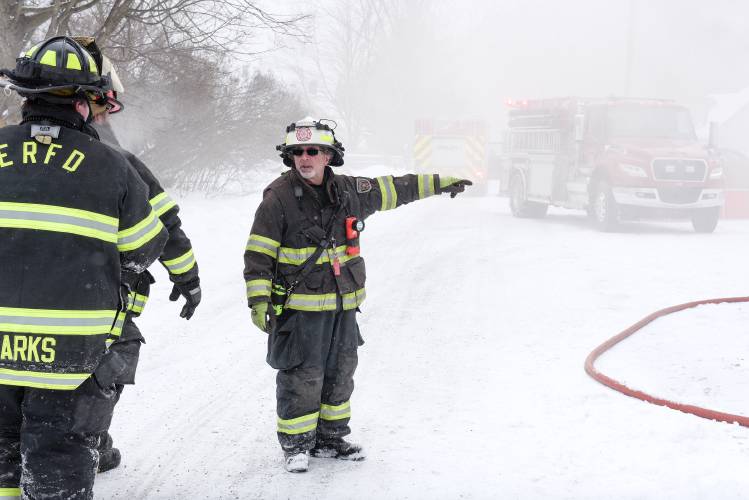 Firefighter points to fire truck in snow