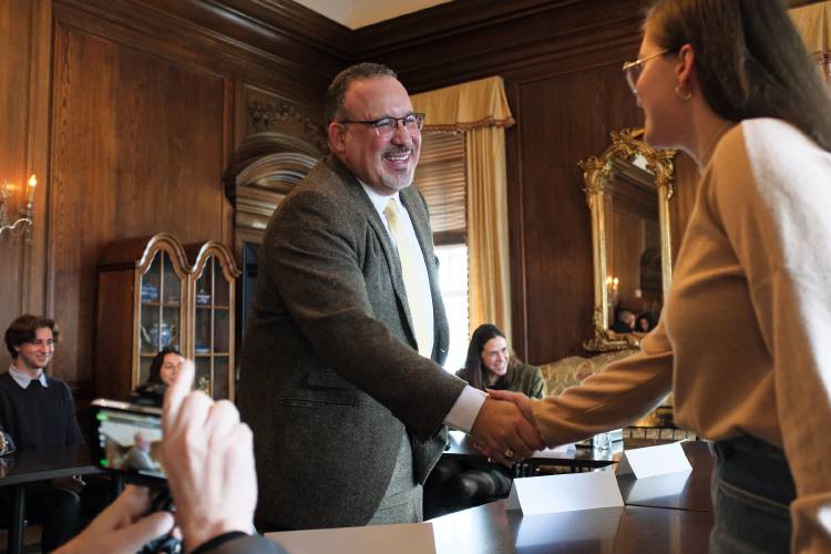 A man shaking hands with a woman in a room.