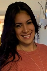 A woman in a pink sweater smiles for the camera.