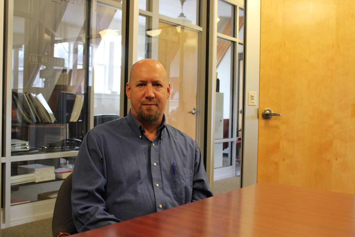A bald man sitting at a desk.