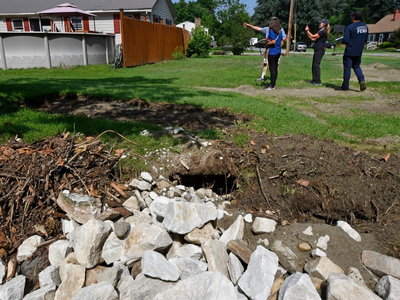 a man is standing next to a hole in the ground.