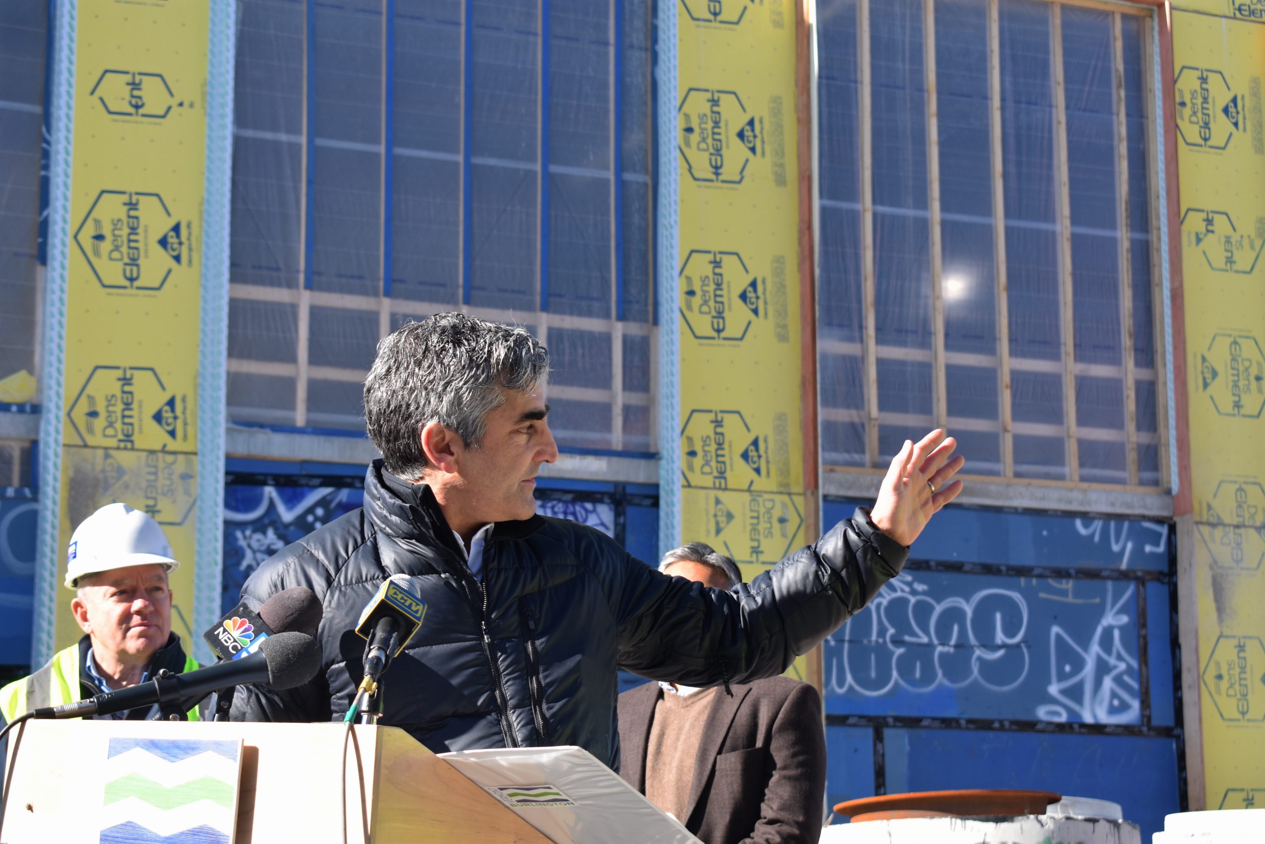 A man standing at a podium in front of a building.