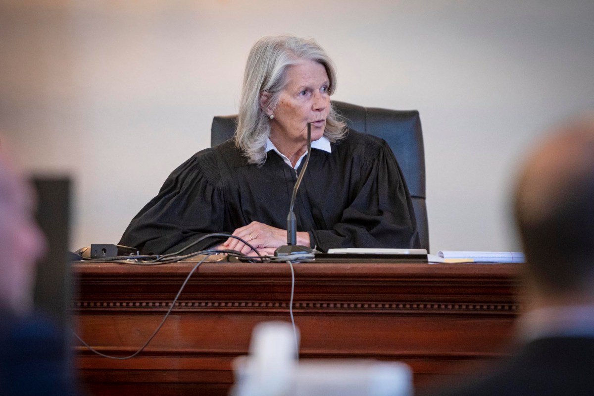 a judge sitting at a desk in a courtroom.
