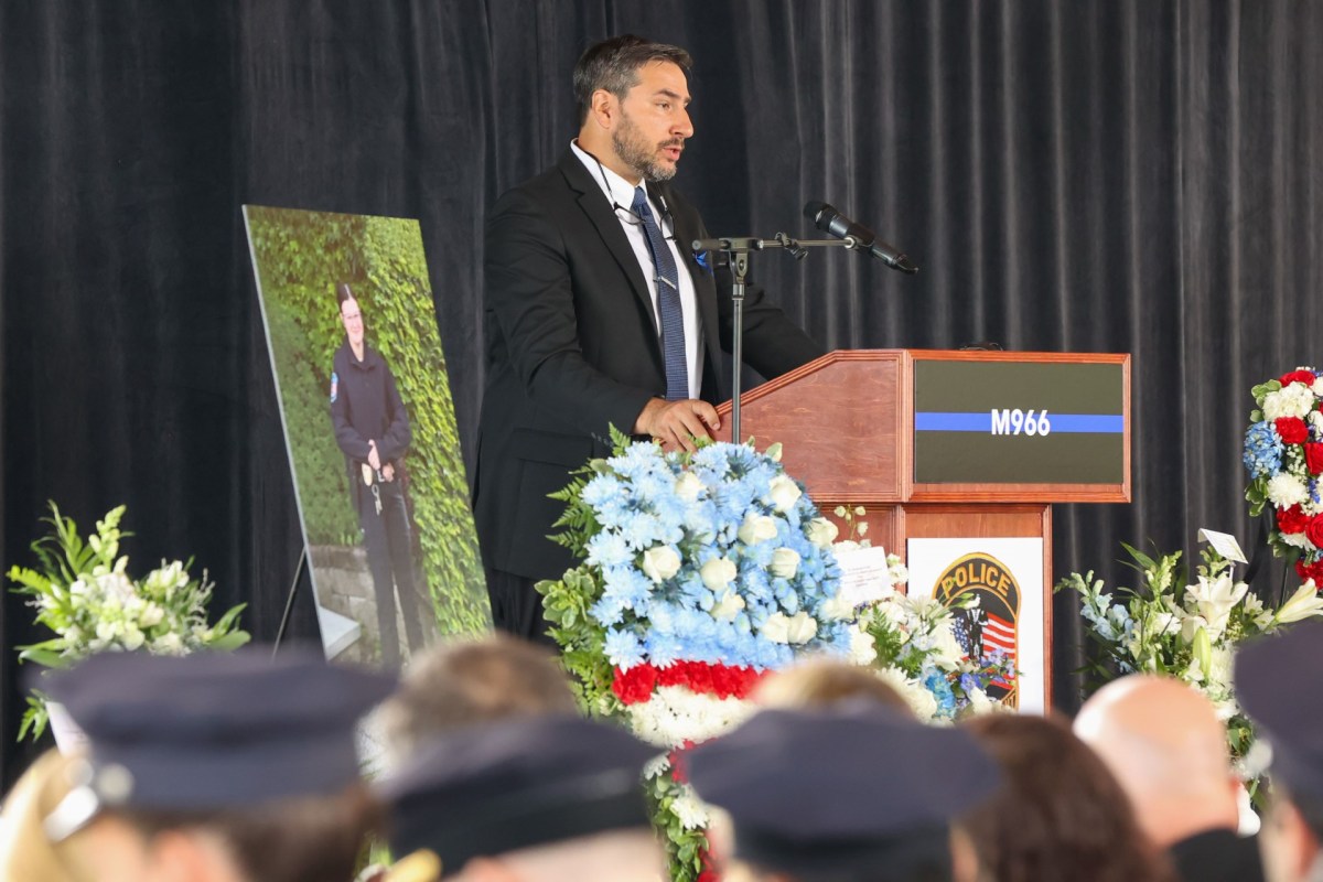 a man speaking at a podium in front of a group of people.