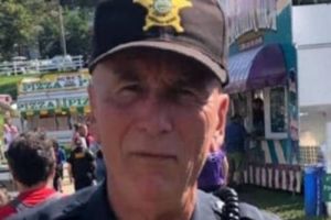 a police officer standing in front of an amusement park.