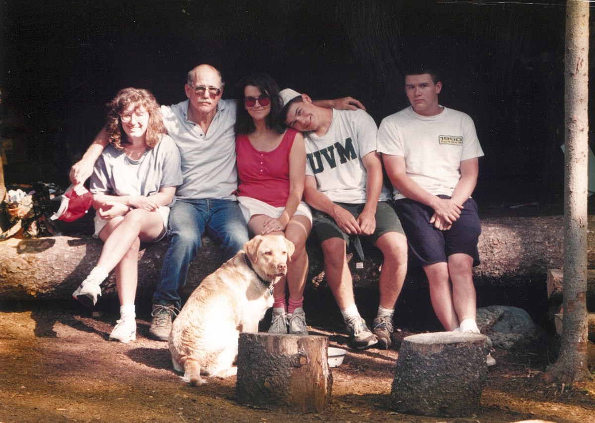 Parents with three teenage children and a dog at a campsite