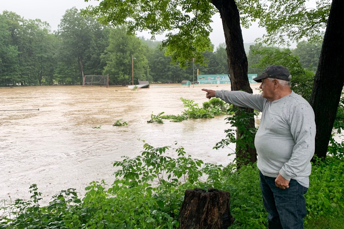 a man pointing to a flooded field.