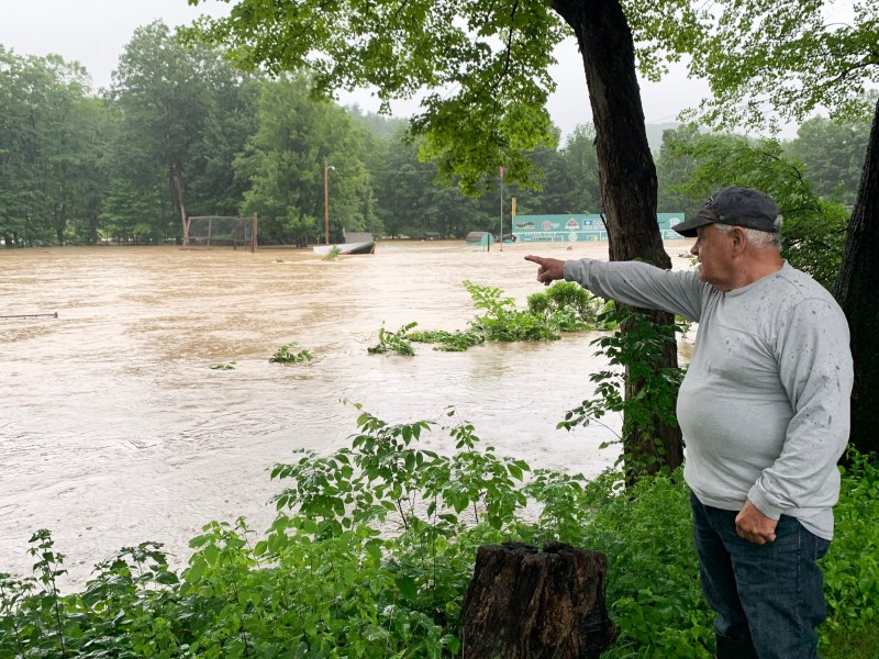 a man pointing to a flooded field.