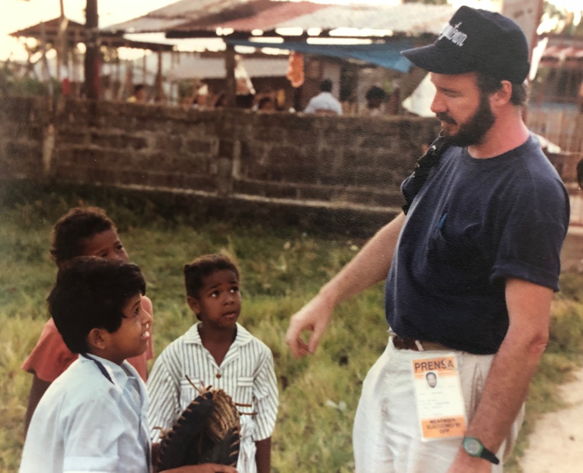 a man standing next to a group of children.