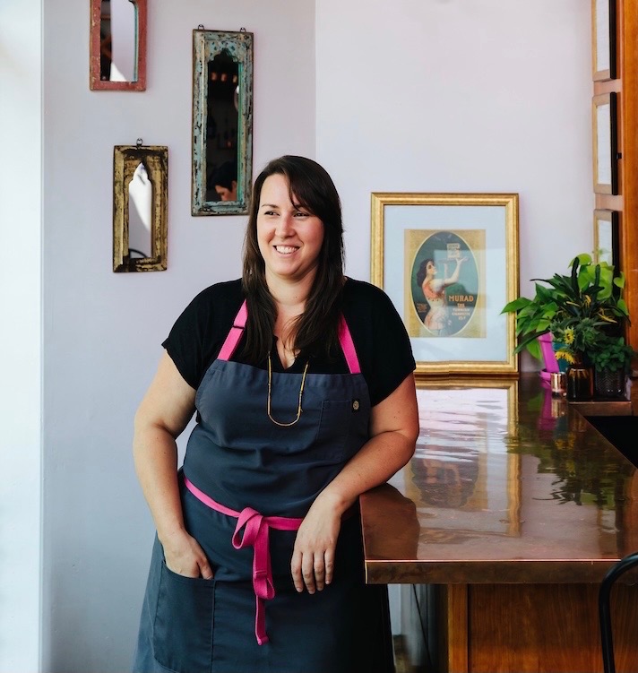 Woman in apron stands at counter