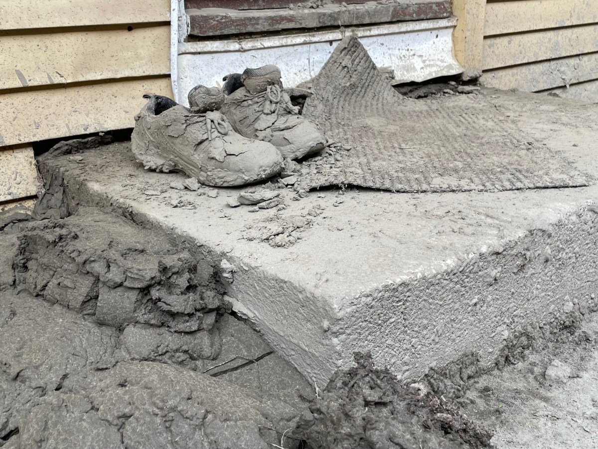 A pair of shoes sitting on a piece of concrete.