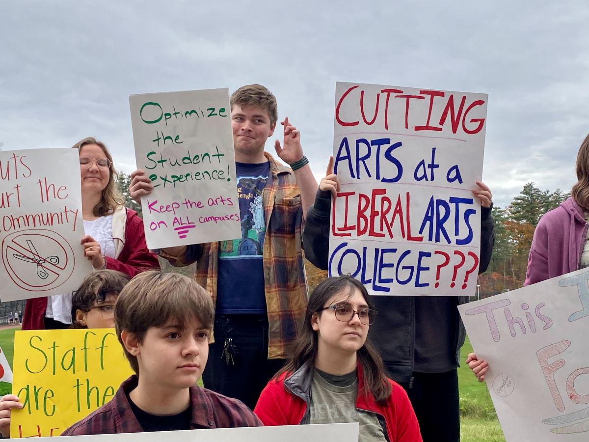 A group of people holding signs in a field.