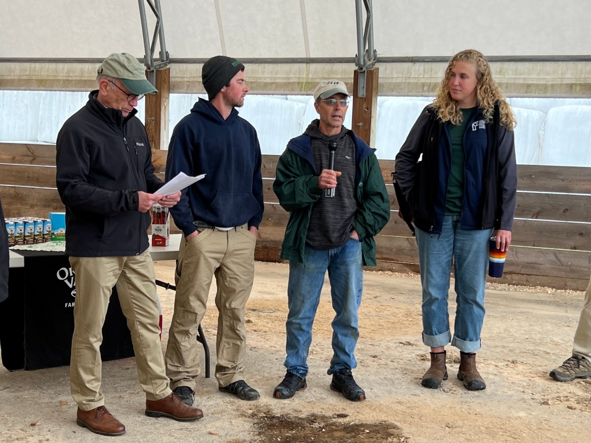A group of people standing next to each other in a barn.