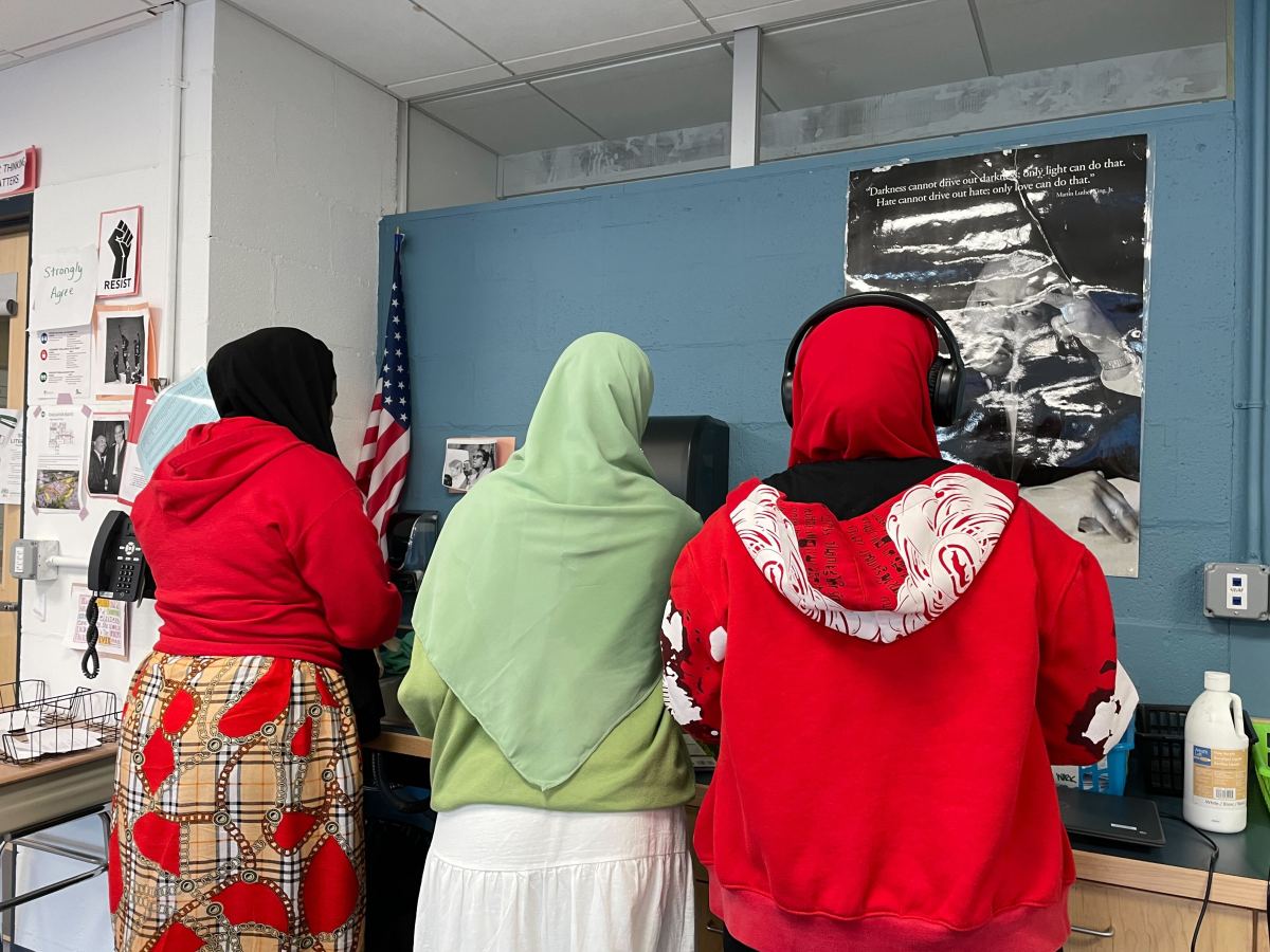 A group of people standing in a classroom.