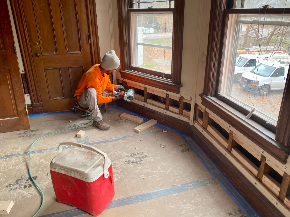 A man is working on a room that is being remodeled.