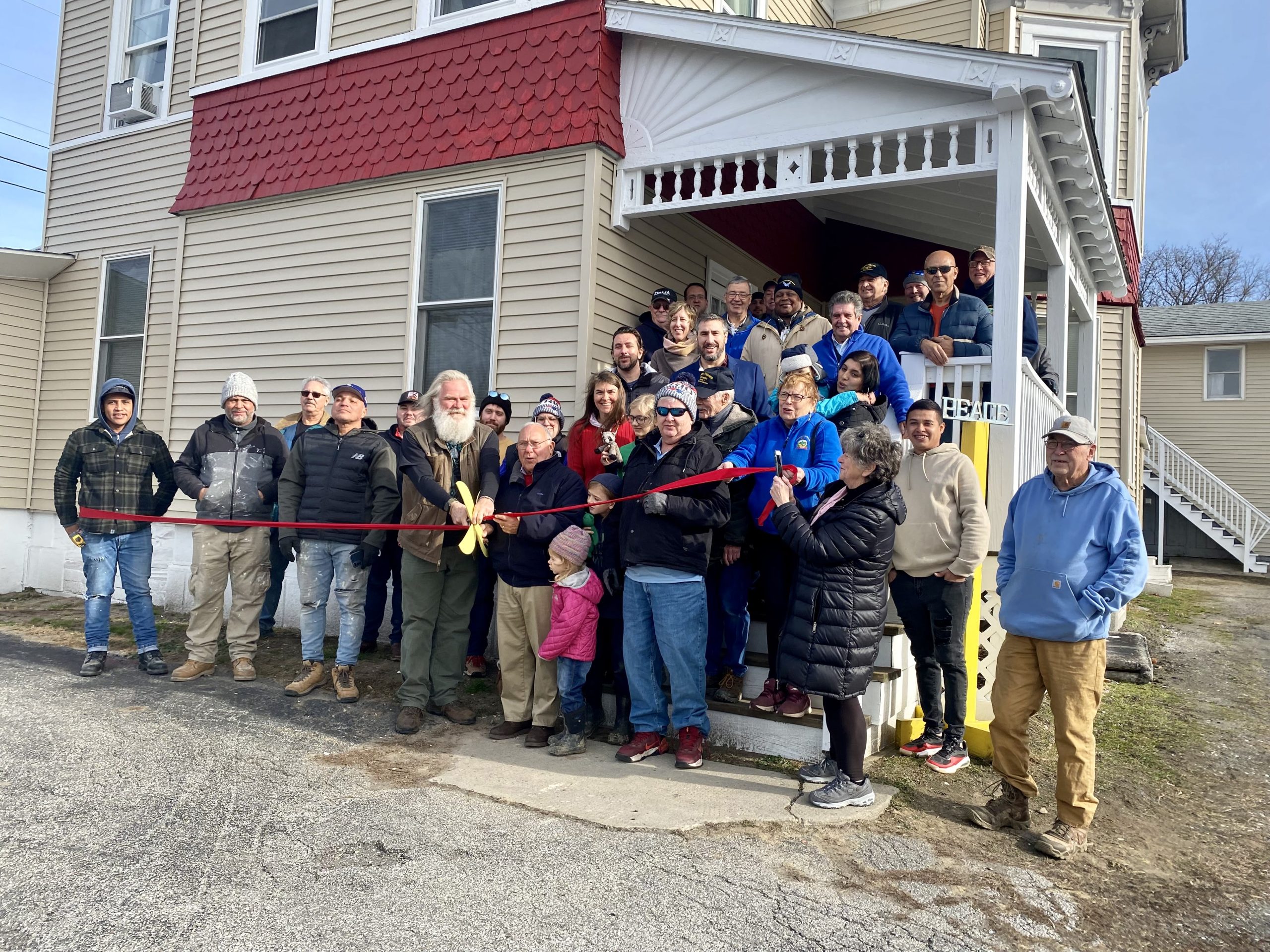 A group of people standing in front of a house.