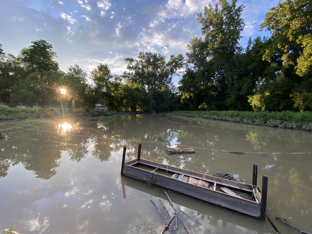 a boat sits in the middle of a muddy river.