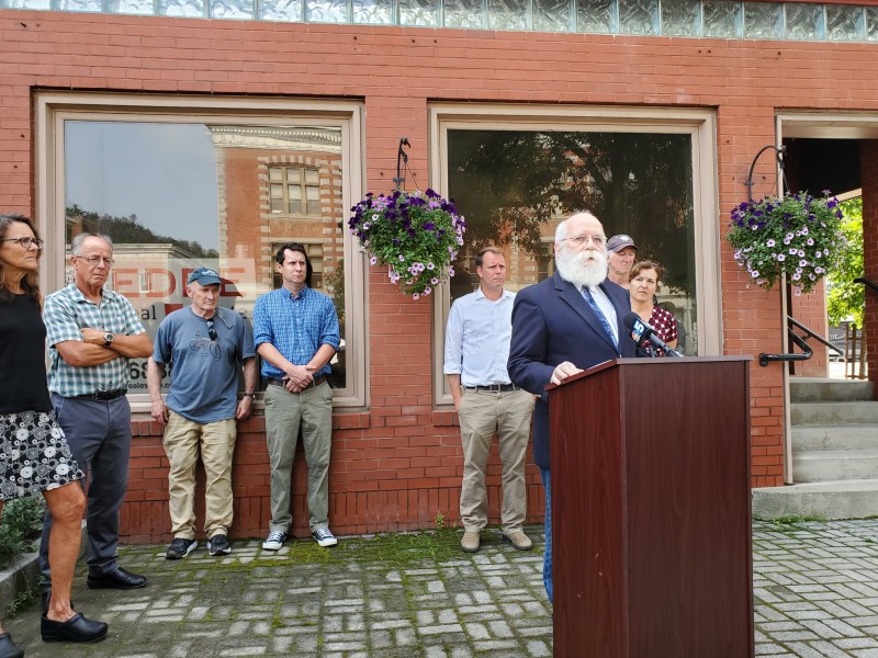 a man with a beard standing in front of a podium.