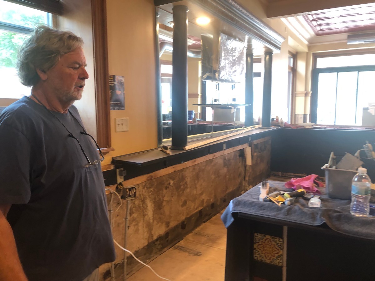A man standing in front of a counter in a restaurant.