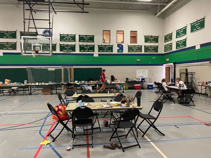 a gymnasium filled with tables and chairs.