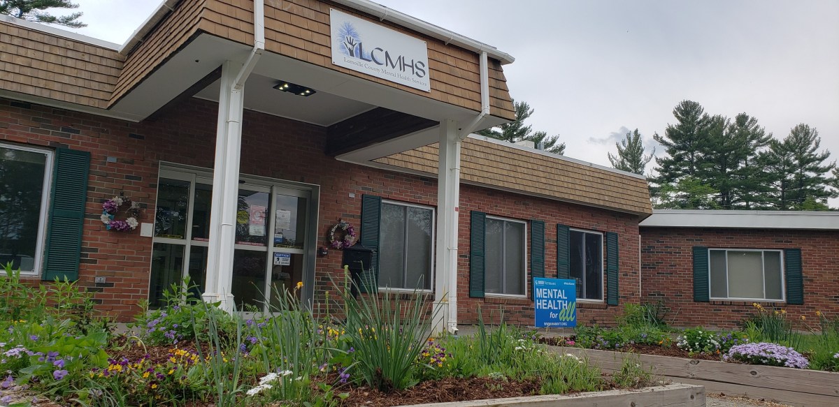 the front of a building with flowers in front of it.