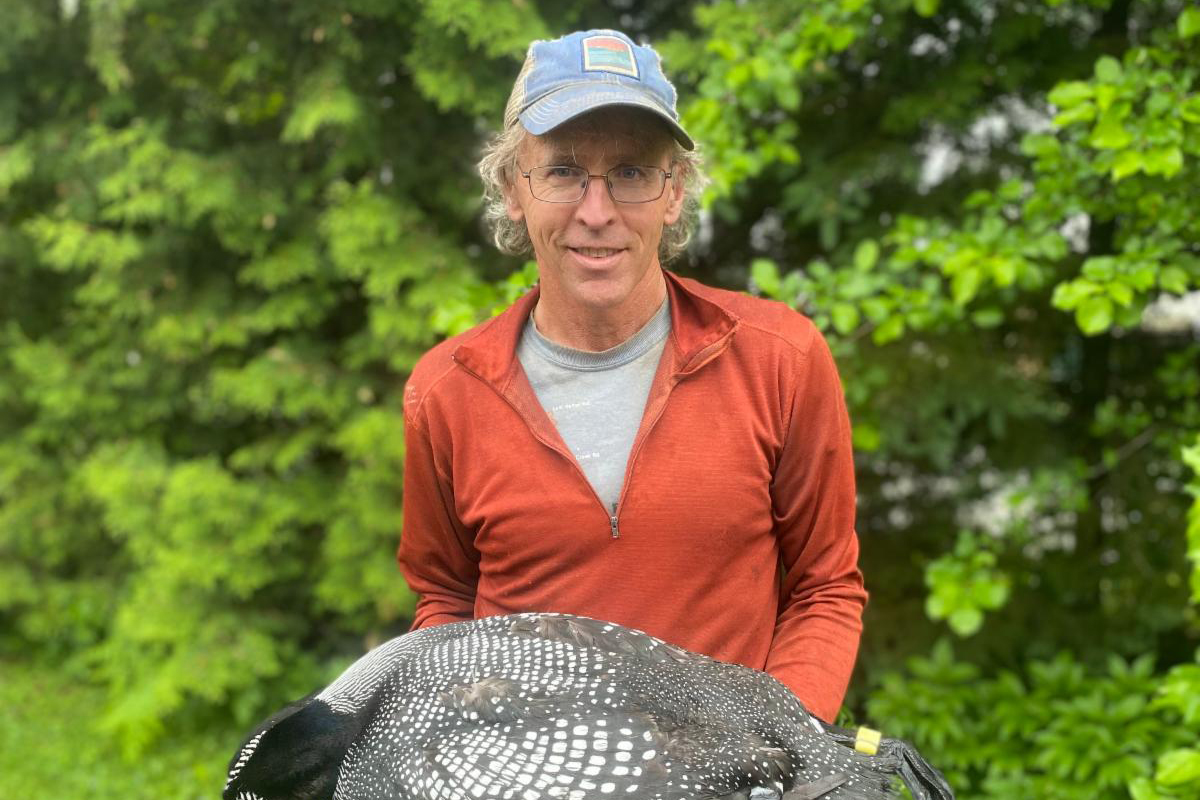 a man holding a large bird in his hands.