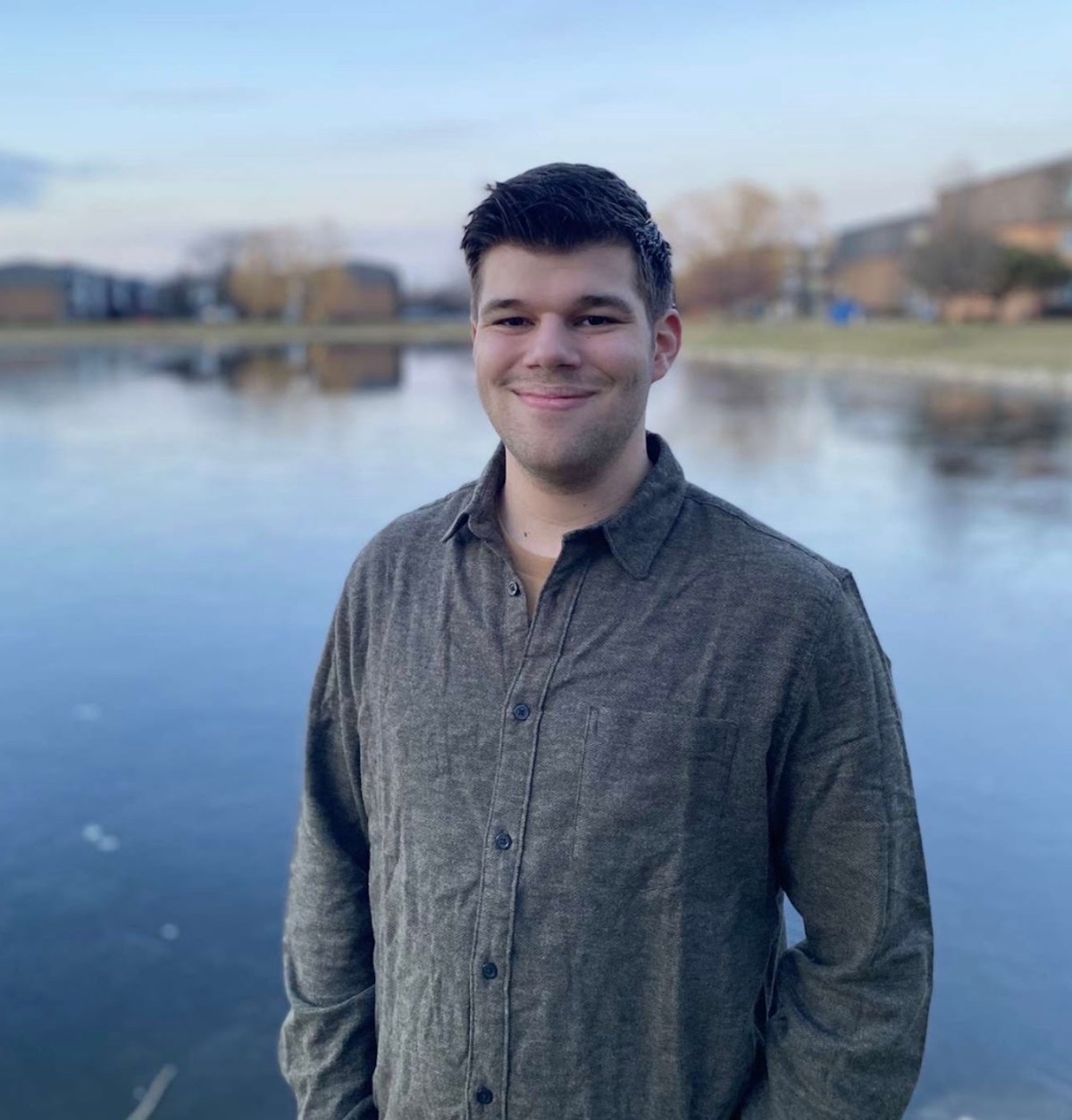 A man standing in front of a body of water.