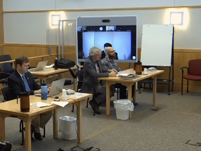 A group of people sitting in a courtroom.