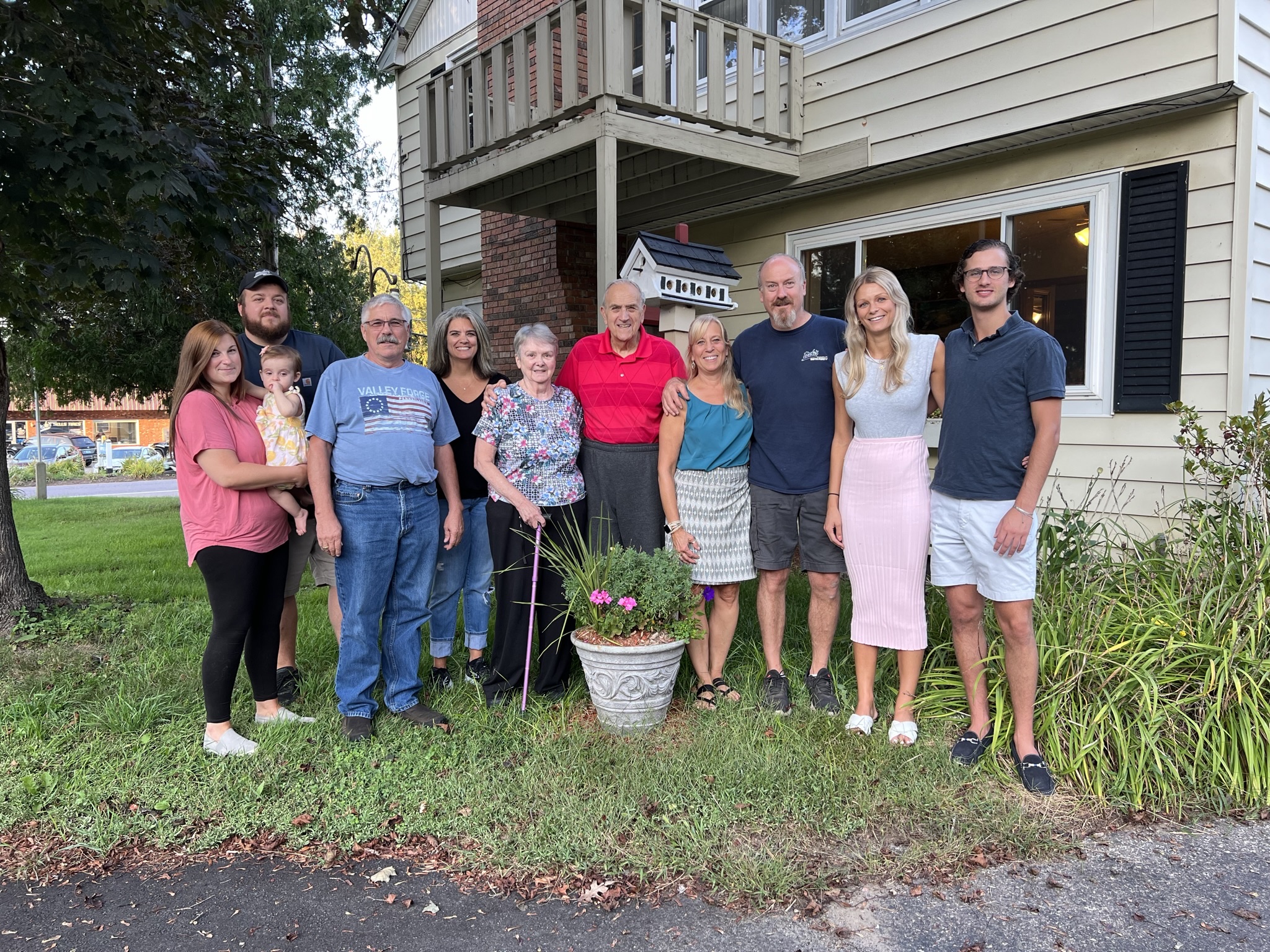 Family members pose in front of house