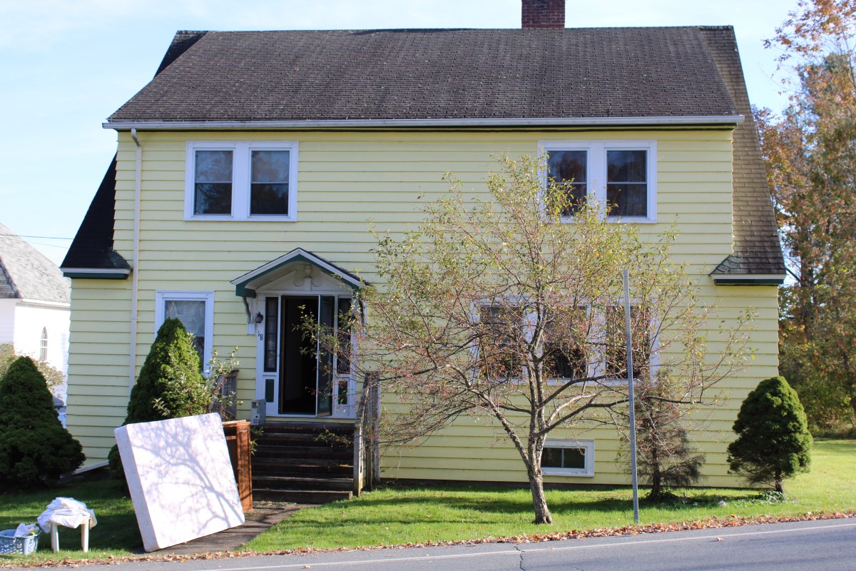 A yellow house on a street.