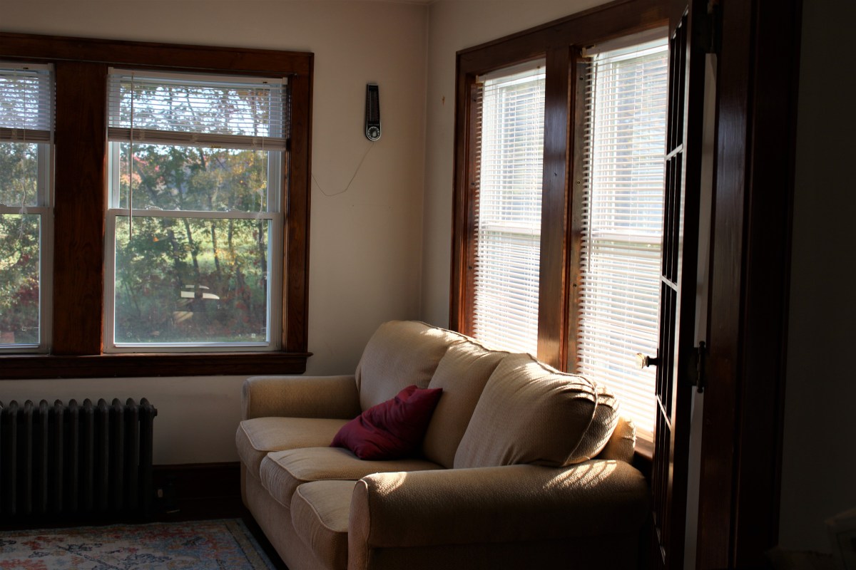 A couch in a room with a window.