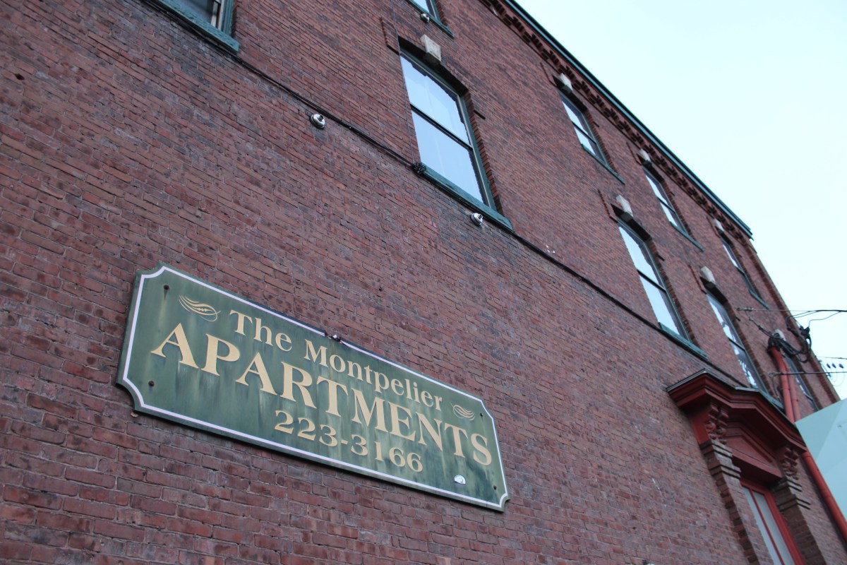 A sign on the side of a brick building.