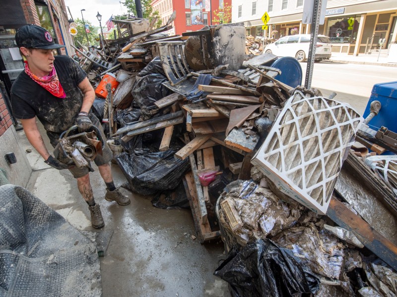 a man is standing next to a pile of debris.
