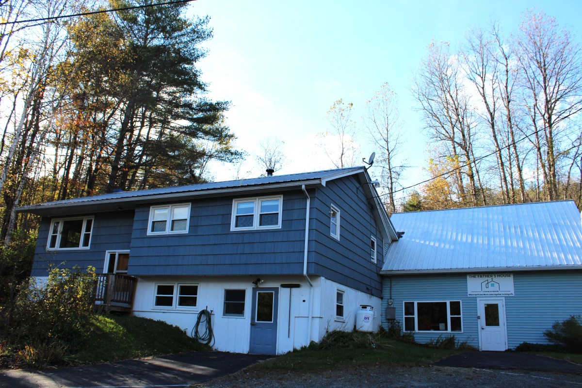A blue house with a white roof.
