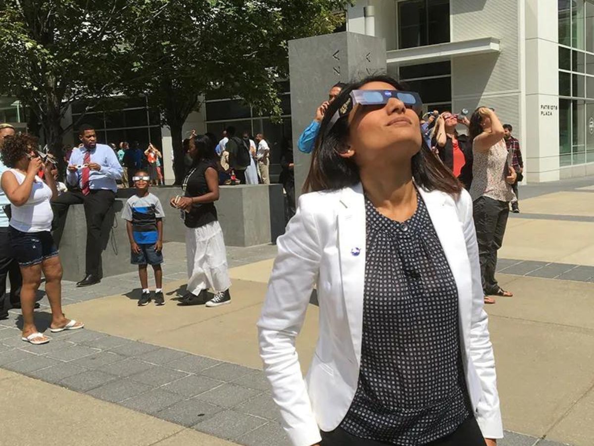 A woman is standing in front of a crowd of people.