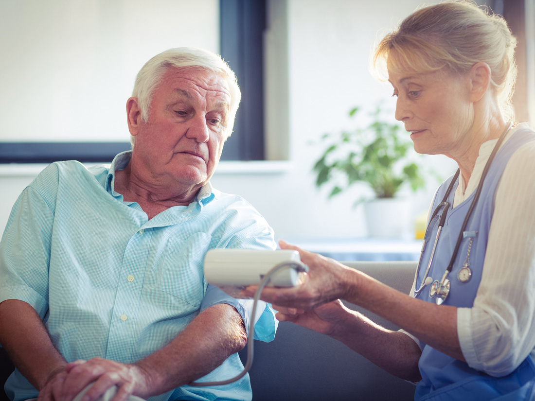 A nurse is checking a patient's blood pressure.