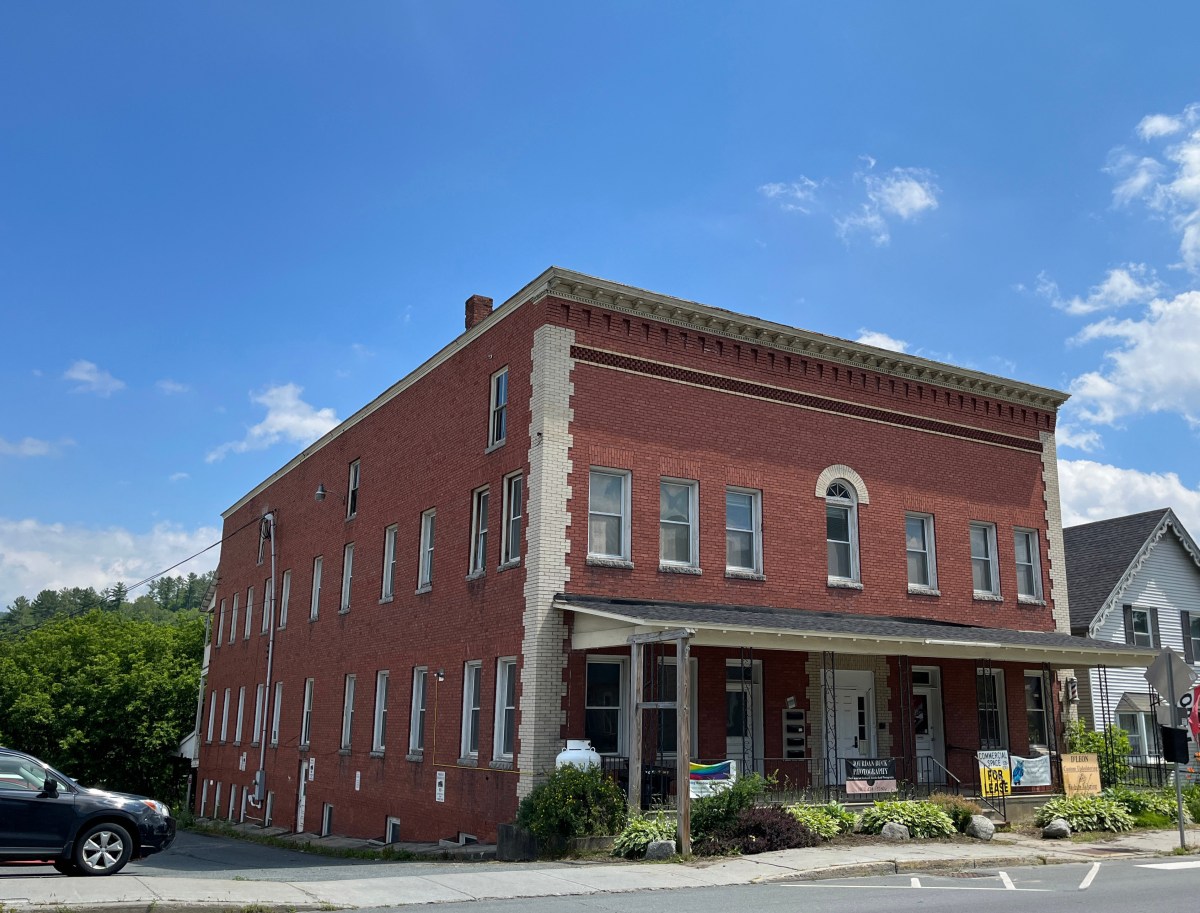 A red brick building on the corner of a street.